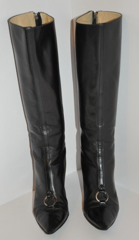 Jimmy Choo black calfskin leather high-boots is accented with a buckle on front. Heels measures 3 1/2