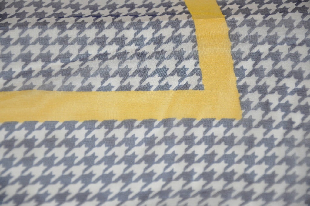 Der marineblau-weiße Schal aus Seidenchiffon ist mit einem gelben Band eingefasst und mit handgerollten Kanten versehen. Schal misst 21