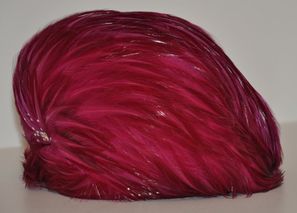 Jack McConnell's cloche has bold Shades of Fuchsia highlighted with specks of micro rhinestones make for a festive sight. Bright and happy! Circumstance measures 22