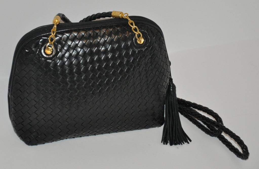 Questa meravigliosa borsa a tracolla in pelle d'agnello intrecciata ha una doppia tracolla anch'essa intrecciata con hardware dorato. Gli spallacci misurano 21