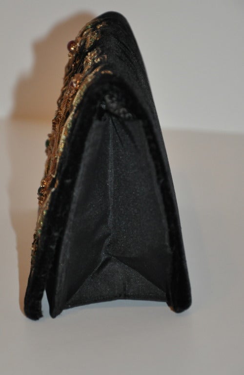Fabrikant's combination of black velvet and black silk evening bag is heavily embellished with with gold and copper along with semi-precious stones. embellished is raised as a three-D effect, and is all hand-done.
   Bag measures 8