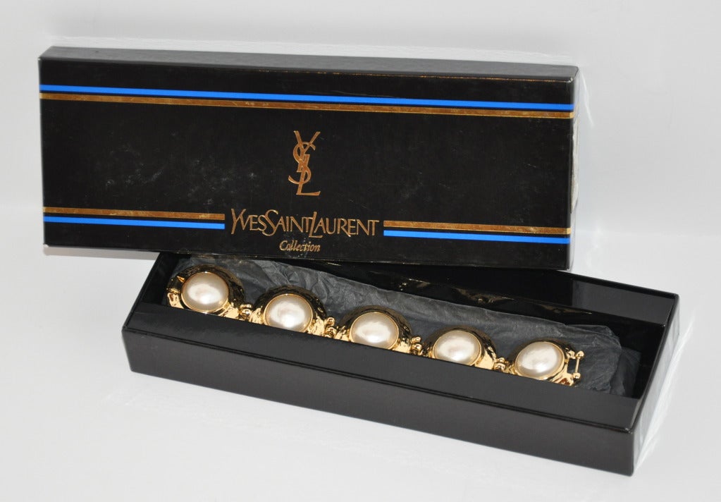 Yves Saint Laurent's gilded gold hardware with large faux pearl centered bracelet measures 8