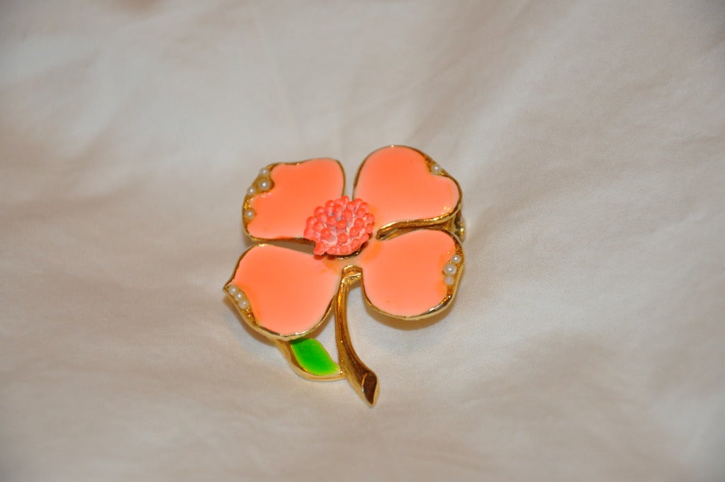 Cette broche en or doré est finie avec de l'émail aux teintes corail et vert et est surmontée de micro perles de rocaille.
   La broche mesure 1 14/16