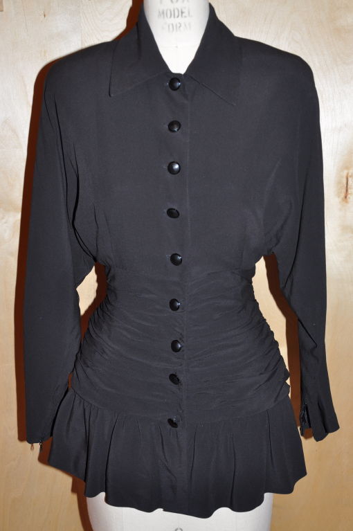 Jean-Louis Scherrer black ruffled cocktail blouse is fully-lined with gathering near the bottom. Where the gathering is located, there are four (4) buttons and also six (6) snaps to secure after the hidden zipper (which is underneath). Overall the