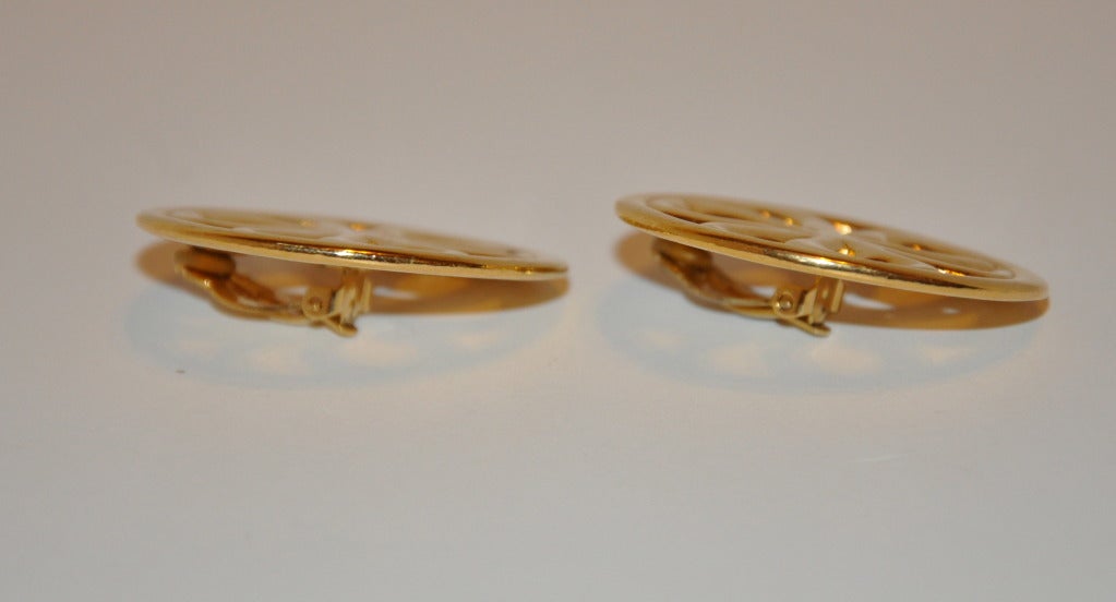 Les boucles d'oreilles rondes à clip en or doré de Givenchy sont centrées sur un 