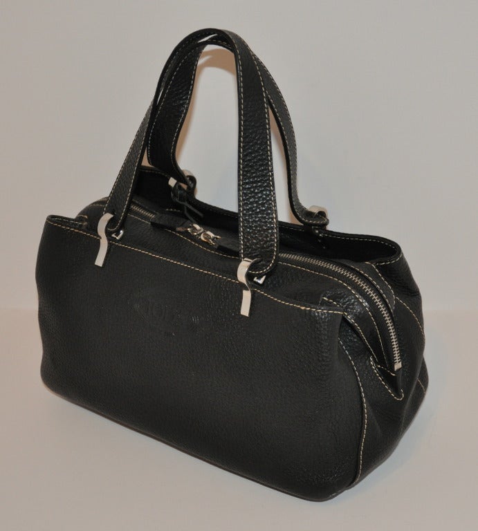 TOD's textured black leather has three compartments. The center compartment comes with a zippered top with a choice of having the zipper open at either end, or, at the center. The other two open compartments are located on either side of the center