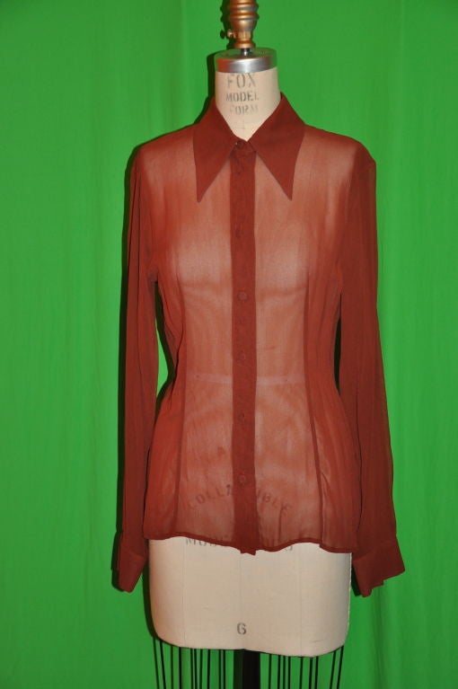 Alberta Ferretti brick-colored sheer classic blouse. This blouse has seven buttons and a single button on each cuff. There are two slim darted panels on both the front and back of the blouse for a slim fit. The collar are pointed. The buttons are