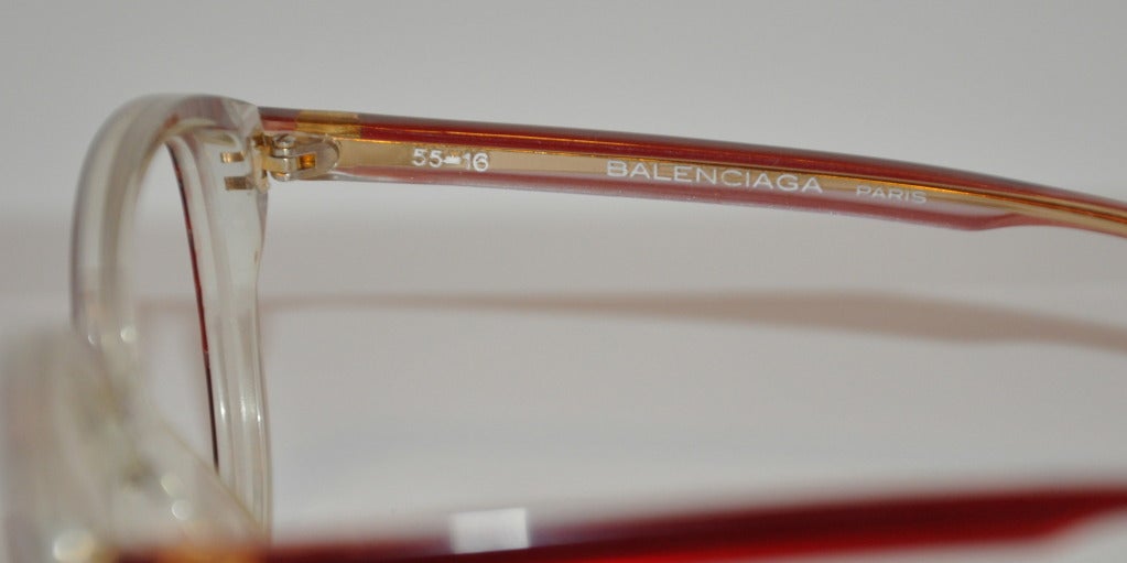 Balenciaga Red & clear lucite frame glasses are lens-less. Glasses measures 2 1/8