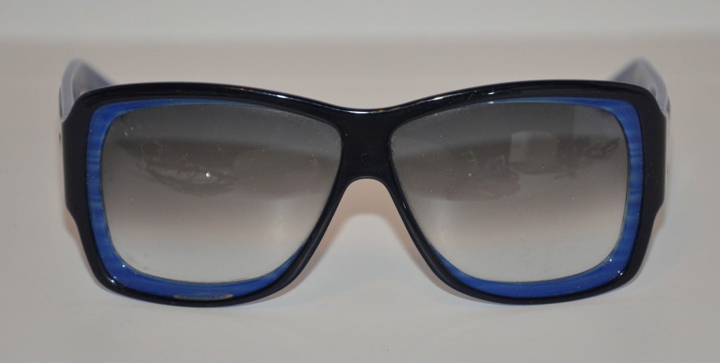 Die wunderbare Sonnenbrille von Yves Saint Laurent ist in französischem Blau gestreift und mit schwarzen Akzenten versehen. Die Seiten haben ein silbernes Namensschild mit 