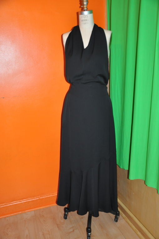 This Masuda black viscose halter maxi dress has a asymmetrical hemline. And flows when walking, giving an airiness. There are two deep pockets hidden on the sides and the waistband scoops lower in the back for sexiness. The center back zipper