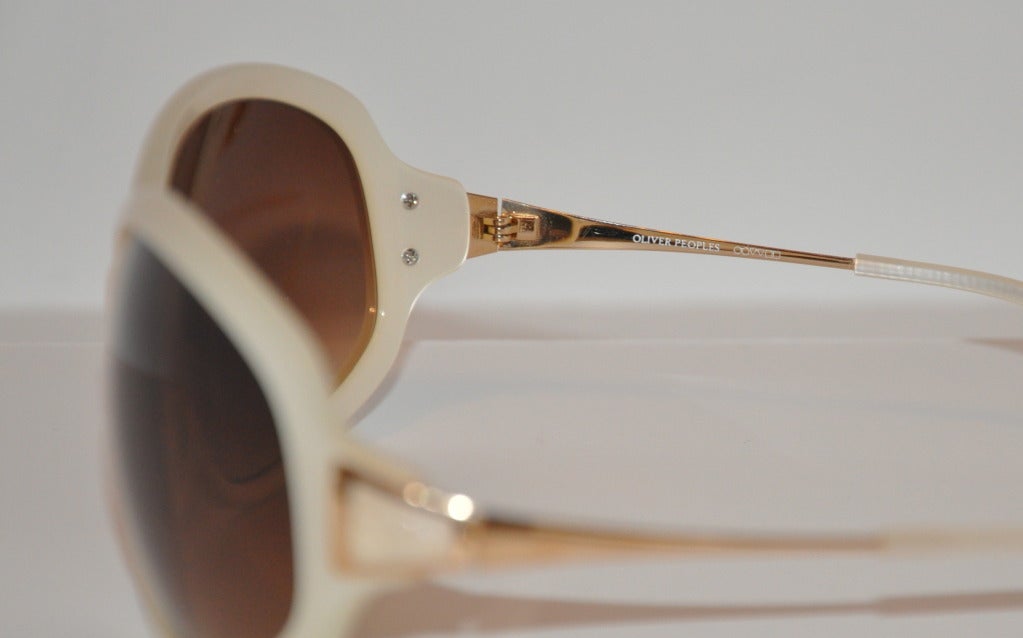 Oliver Peoples pearl finish along with gold hardware accents sunglasses measures 2 1/4