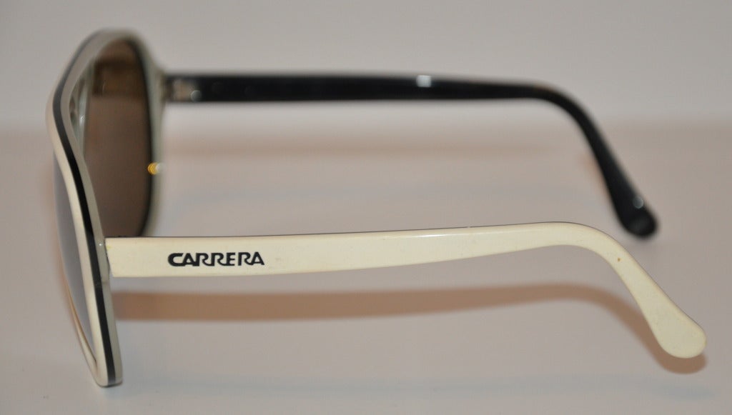 Carrera white with black trim lucite mirrored sunglasses  measures 2 1/4 inches; in height and 5 1/2 inches; across the front. The sides are 5 inches in length. Both exterior sides has Carrera etched into the lucite in black. Interior is gray and