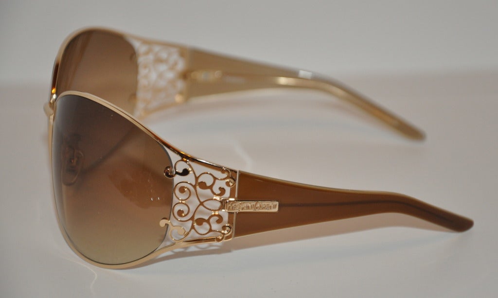 Yves Saint Laurent gilded gold framed wrap-around sunglasses are detailed with gilded gild etched on both corners along with 