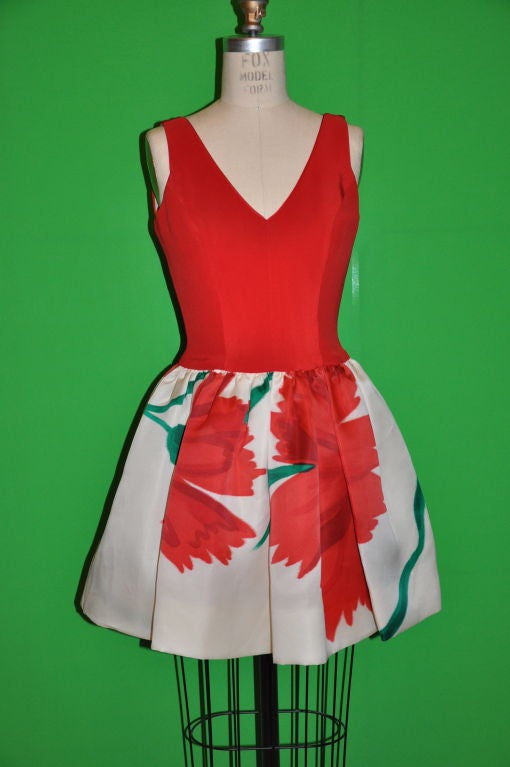 This wonderful James Purcell for Tissu Bucoi cocktail dress has a bold Abstract Floral print. The bodice is in solid red silk, while the skirt is in silk taffeta. Both the front and back has a 'V' neckline.The dress is fully lined in cream silk on