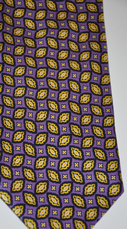 Paco Rabanne's silk tie leave print in yellow and black with a wonderful purple background. Lining is in a warm blue shade. 
   The tie measures 3 3/4
