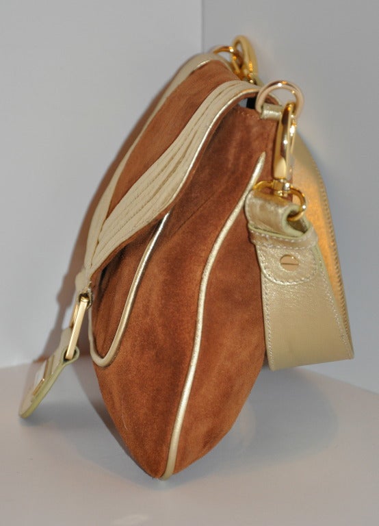 Halston's warm brown suede with metallic gold calfskin leather has details of superb  top stitching along with metallic gold piping throughout this handbag. 
   The straps can be detachable with the choice of wearing this wonderful bag as a