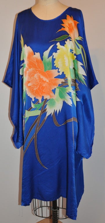 Blue Silk caftan is wonderfully hand-painted in floral with bright colors of yellow, tangerine and coral. With the back in floral along with two butterflies.
   Wonderful for lounge wear at home and by pool side, or when at home playing Hostess. 

