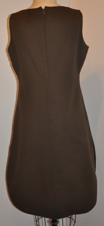 Geoffrey Beene's fully-lined taupe scallop-hem dress has an invisible zipper located on the back's center which measures 21