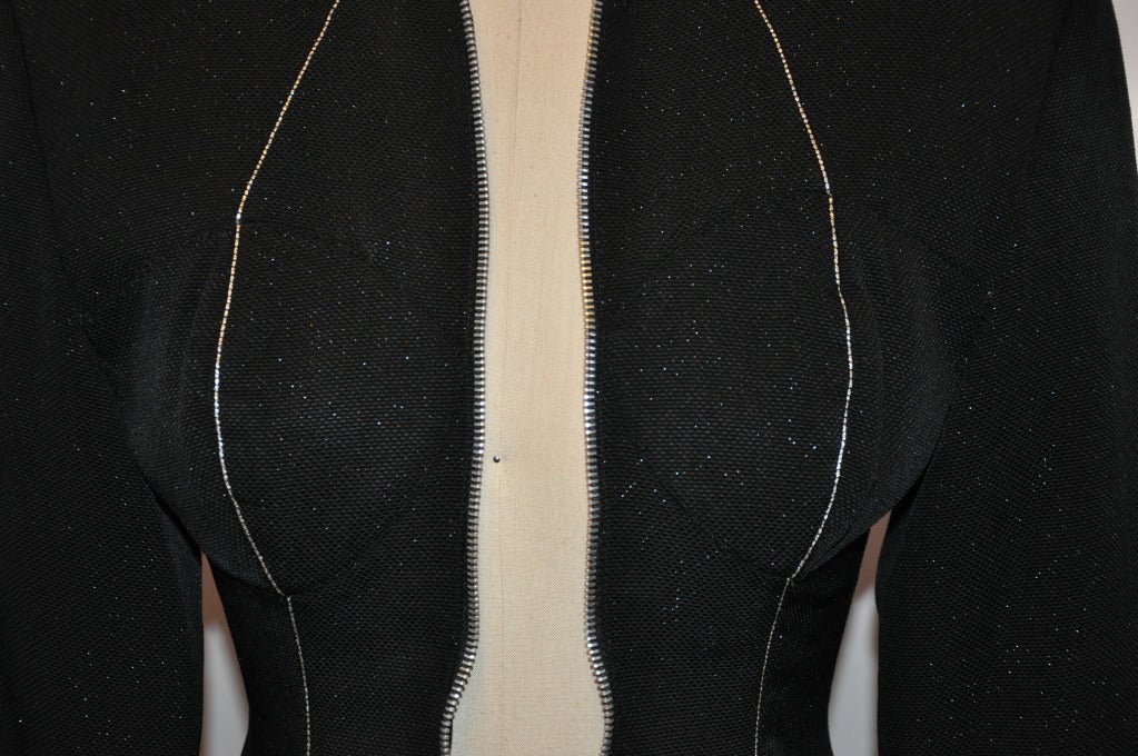 Yohji Yamamoto noir avec des mouchetures de fils d'argent métallisé, le devant zippé a des poitrines rembourrées détaillées. La fermeture à glissière et les boutons de manche en métal argenté mettent en valeur cette veste. Entièrement doublé.
   La