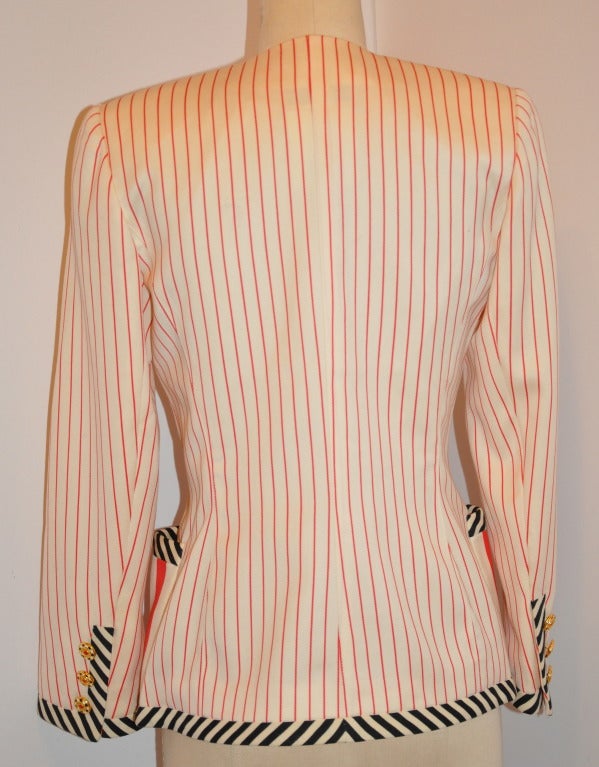 La veste multi rayures Emanuel Ungaro entièrement doublée présente des rayures audacieuses noires, blanches et rouges accentuées par des boutons métalliques colorés sur le devant et également sur le bord des manches. Il y a deux poches plaquées