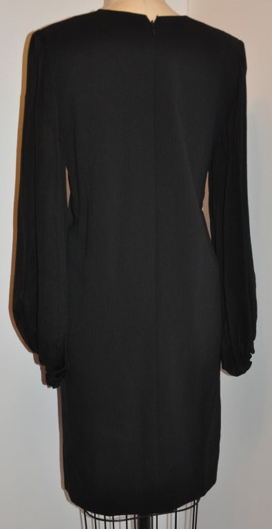 Carolyn Roehm black silk crepe cocktail dress is fully lined with black silk. The silk chiffon sleeves has a suggestion of gathering detailing along the shoulders. The chiffon sleeves are wonderfully cut full and comes to life with your movement or