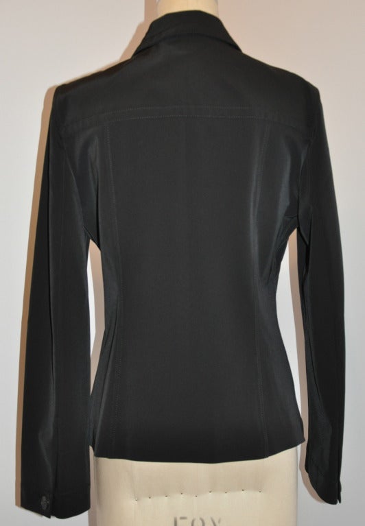 Die schwarze Stretch-Button-Down-Jacke von Prada ist auf der Vorder- und Rückseite mit edlen Steppnähten versehen. Auf der Vorderseite befinden sich zwei Brusttaschen, die mit vier Knöpfen verschlossen werden können.
   Ärmel hat einen Fold-over