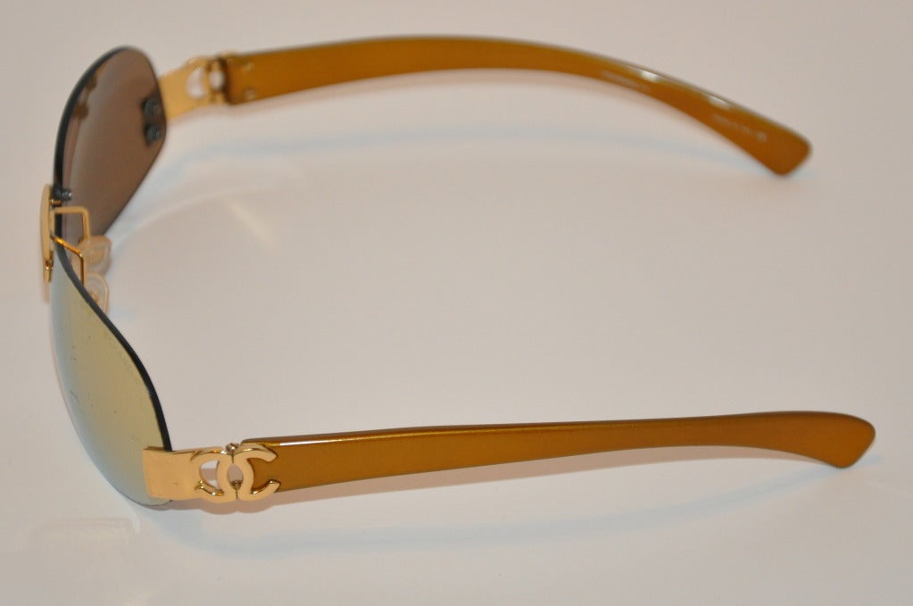 Chanel mirrored gold frame sunglasses comes with an extra set of mirrored lenses for replacement when needed.
   Frames are lightweight gold lucite accented with hardware along with the original case.
   Height measures 1 5/8