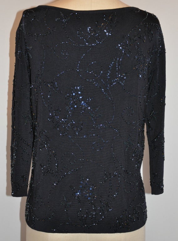 Carmen Marc Valvo black jersey stretch pullover is detailed with specks of micro bead work.
   Back length measures 20 3/4