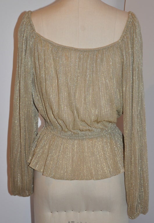 This classically gold lame scoop neck evening blouse can be worn as shown, or, off the shoulders. The fabric below the elastic waistband can be tucked under and worn as a cropped top for a more casual appearance.
   Along the top of the sleeves by