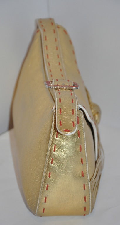 Diese wunderbare Emanual Ungaro Schultertasche aus goldfarbenem Lammleder hat detaillierte handgenähte Details in einem warmen Ziegelbraun, die das goldfarbene Leder betonen. Das Innere ist in Mandarine gefüttert und verfügt über ein Fach mit