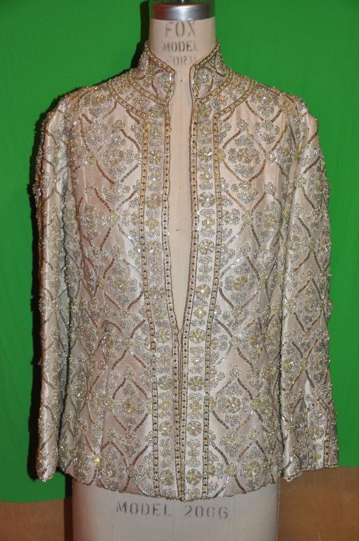 Cream colored silk jacket is heavily embroidered with Micro seed beads, micro seed pearl beads, micro sequins, Swarovski crystals. Jacket was made-to-order for a socialite. The jacket is fully lined, and is hand-sewn. The mandarin collar stands at 1
