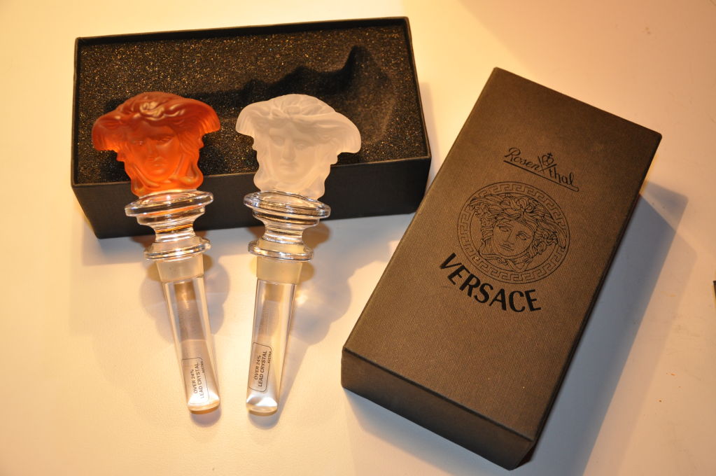 This set of stoppers by Rosenthal for Versace are 24% lead crystal from Austria. One is in the shade of frosted glass, and the other is in a shade of frosted tangerine.