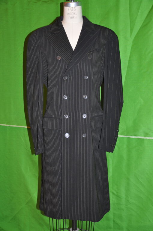 Jean Paul Gaultier multi-pinstripe double-breasted coat has boned bodice on both front and back. The shoulders are padded. There are two pockets in front and also a breast pocket. The front of the coat is semi straight, and the back flares out with