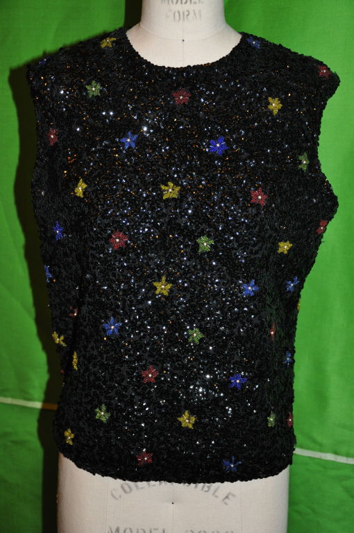 The black woven tank top is covered with black sequins, and embellished with multicolors of reds, yellows, blues, greens and centered with a pearl bead.The center back zipper measures 20