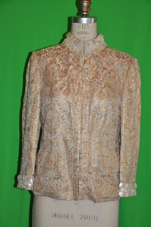 Dolce & Gabbana Gold brocade evening jacket is fully lined. The collar and also on the sleeves cuffs are embellished with multi-size Mother-of-Pearls disks. The Mandarin collar is silk-ribbon lined and stands at 2