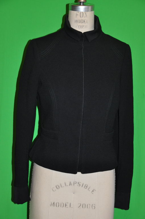 Christian Lacroix light-weight black crepe jacket has six (6) hidden snaps on front, along with two (2) snaps on each sleeve cuff. The jacket is lined in black silk, and the collar can be worn up or down. The cuffs on the sleeve have a 5 1/2