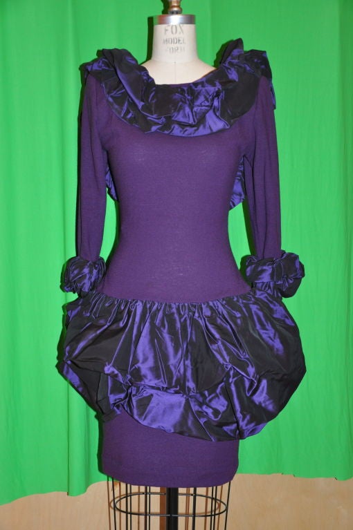 Deep violet-plum wool jersey body-hugging dress is detailed with silk Taffeta to give that Pouf-Pouf effect. There's also Pouf-Pouf detailing along the neckline, skirt and sleeves. The backside has a low scoop to show off your sexily well-toned