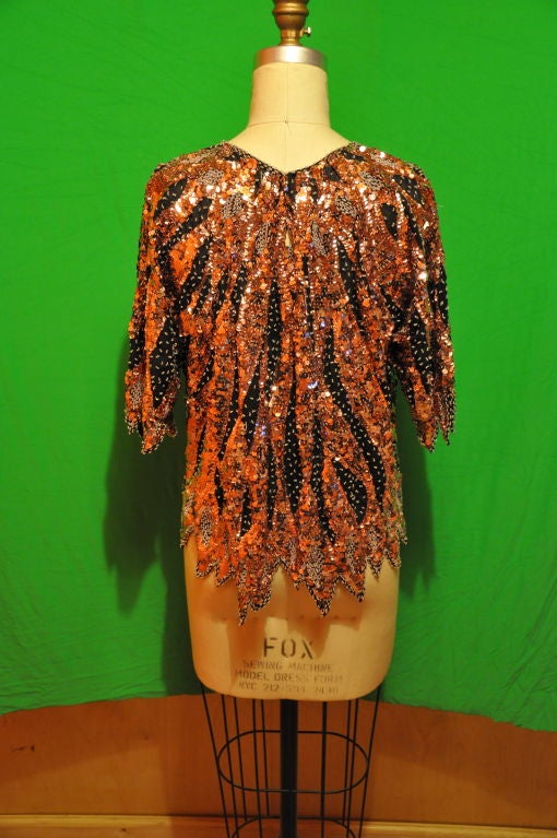 Disco sequin pullover top has colors of Rose gold sequins along with seed beading in pale pink splash within the mixture of sequins. A wonderful combination together. There's a single button on the neck's back. The finishing hem is made to look