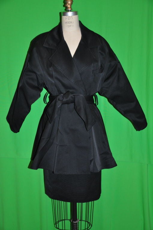 This wonderful Charles Jourdan wrap skirt suit can be worn with the collar up or down. The jacket has padded drop shoulders, and there are 'flat' pleats on both front and back. There are a total of three loopholes for the use of the self belt of the