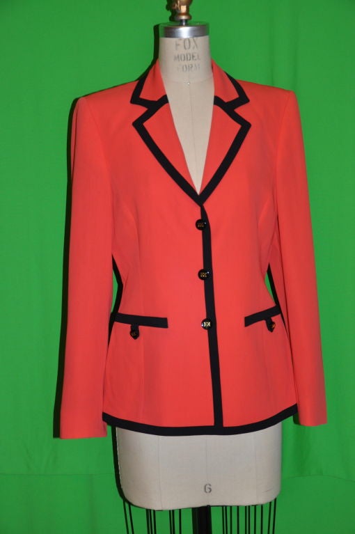 Escada neon red with black trim detailing jacket with signature EE buttons on front and sleeve's cuff. There are two set-in pockets with button embellishment, three button embellishment on each cuff. The front button-hole are finely within the seams