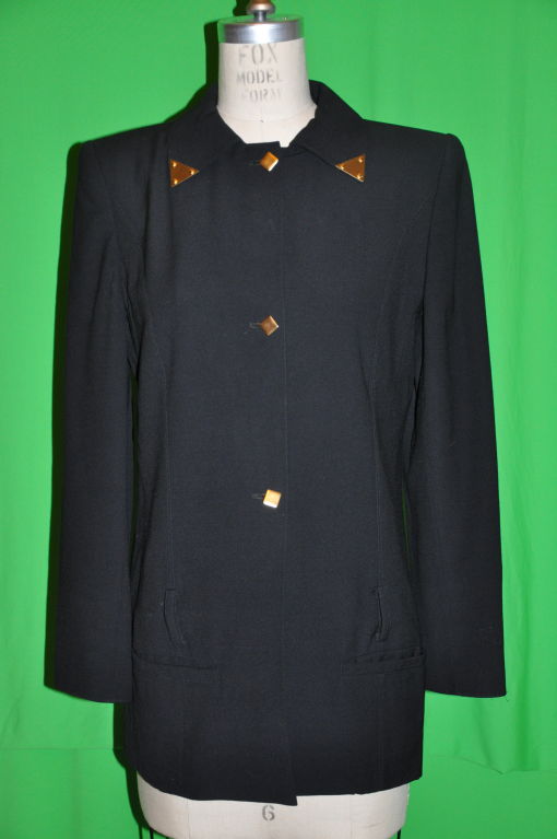 This Claude Montana black fully lined jacket has gold embellishment on collar tips, button front and cuffs. The front has three (3) square gilded gold buttons along with two on each cuffs. The jacket is also detailed with four (4) belt ears just