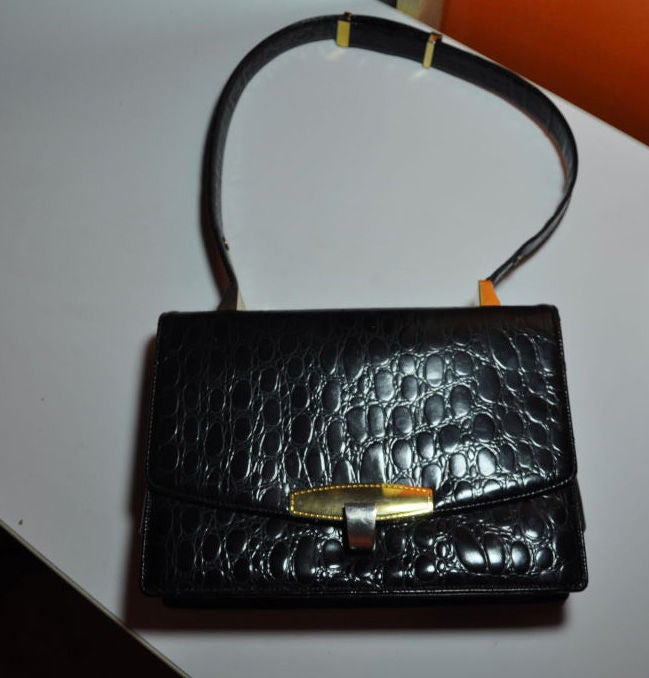 This Koret Black embossed calfskin crocodile handbag has adjustable straps, so your have the choice of a handbag or as a shoulder bag. The bag measures 9
