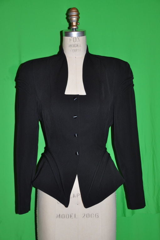 Thierry Mugler black worsted wool jacket has four (4) snap closing on front. There are raised boned quilt detailing on the front & back peplum, and also on the top of the sleeves near the shoulders. There's exquisite fine detailing from the collar