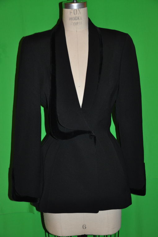 Thierry Mugler black wool jacket has wonderful black velvet detailing along the front lapel and sleeve cuffs. The jacket is doubled-breasted with two hidden snaps on front, along with two hidden pockets in front. The front measures 15