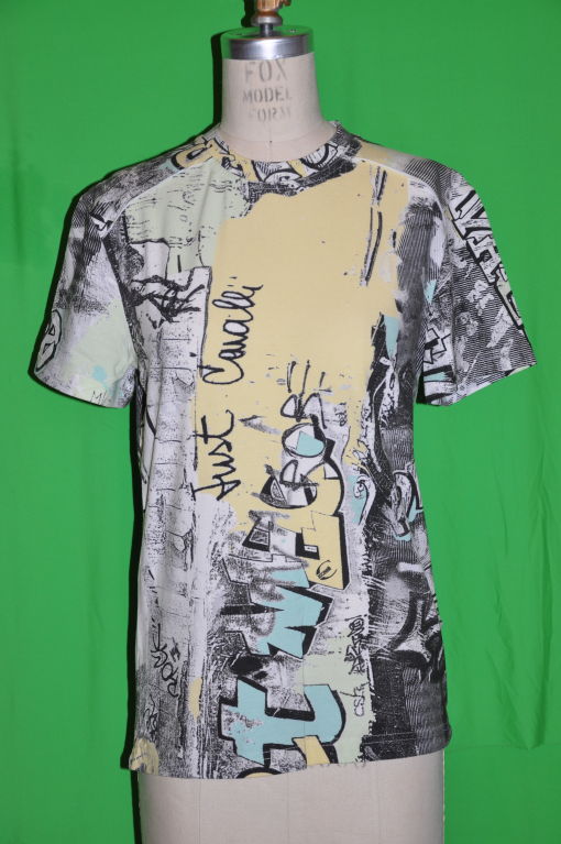 Roberto Cavalli multicolor de amarillos, verdes, grises y negros tiene patchwork en la parte trasera hacia el cuello y también en la parte izquierda de la espalda. La parte delantera mide 22 1/2