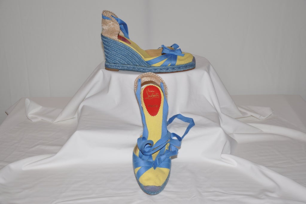 These Christian Louboutin espadrilles have yellow canvas, detailed with sky-blue silk ribbon detailing and also for the tie. The corded roped-soled are detailed also in sky-blue. The sole is rubber. The height is 3 1/2