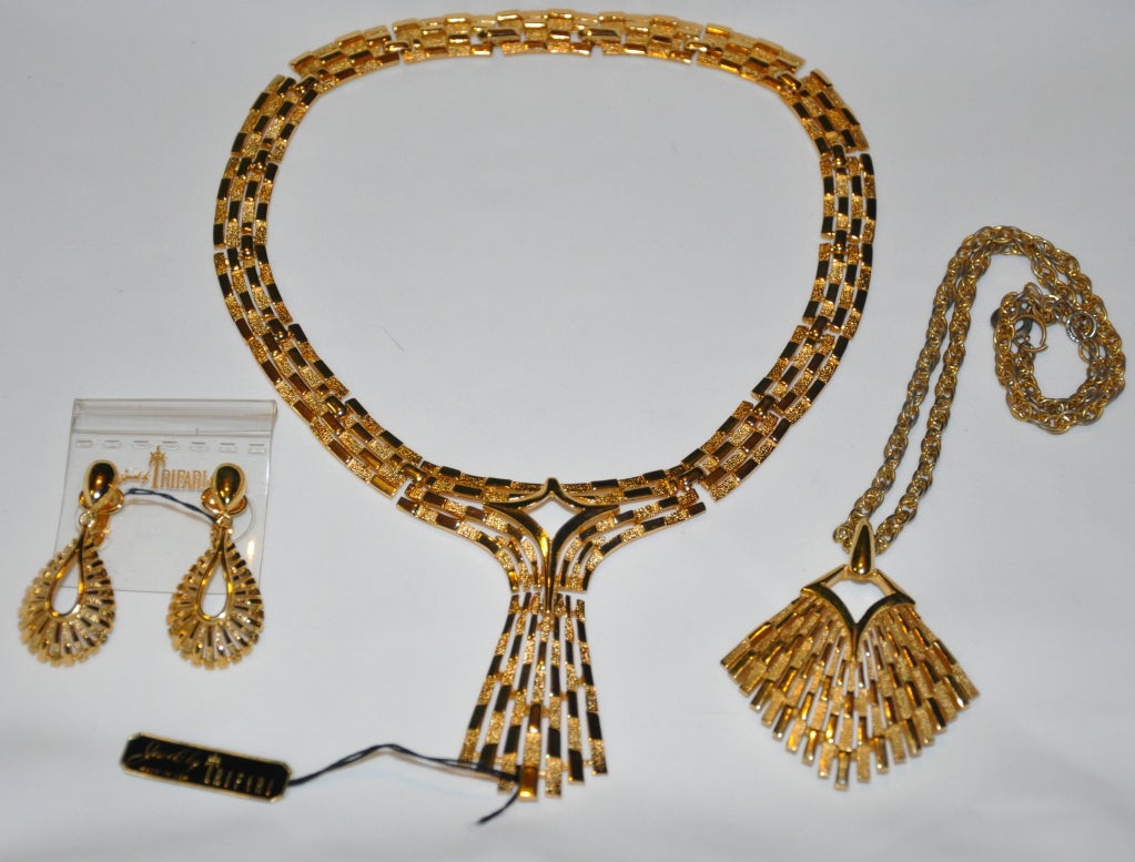 Complete three-piece set of Trifari polished and gilded gold hardware necklaces, plus matching clip-on earrings to wear with either necklaces. The structured gilded gold necklace has a choice of wearing it at 16