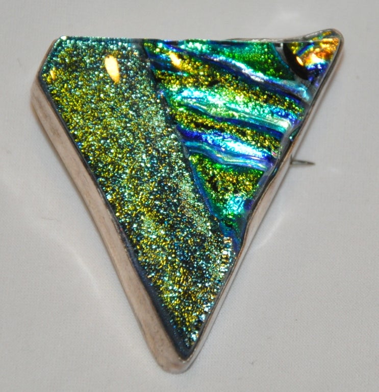 Diese Terika Blake Sterling Silber mit gegossenem Glas kann als Anhänger oder als Brosche getragen werden. Das Schillern des gegossenen Glases schimmert in tiefen Grüntönen verschiedener Schattierungen. Die Details aus Sterlingsilber fallen auf. Die