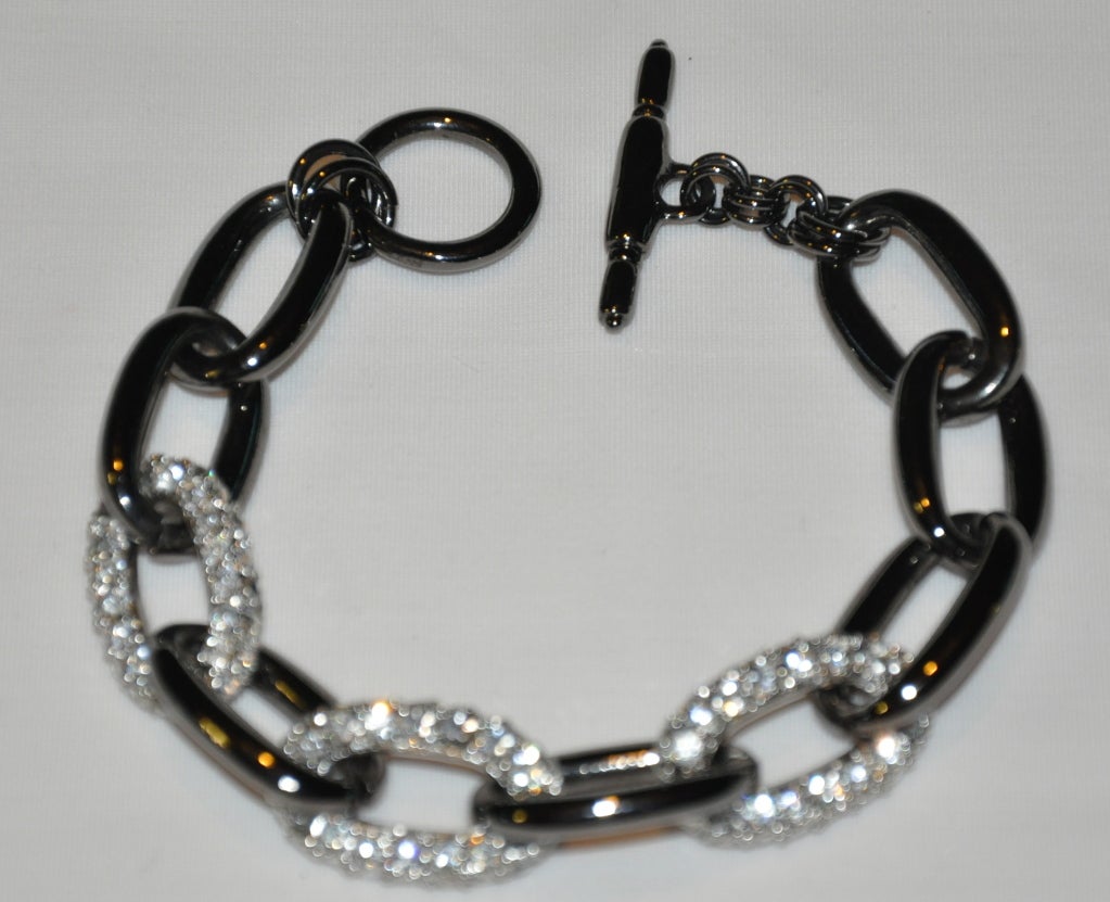 La pulsera de eslabones Kenneth Jay Lane es de tono metal pulido con adornos de cristales de Swarovski. Las iniciales KJL están marcadas en la pulsera.<br />
   La pulsera mide 8' de longitud, la anchura es ligeramente superior a 1/2