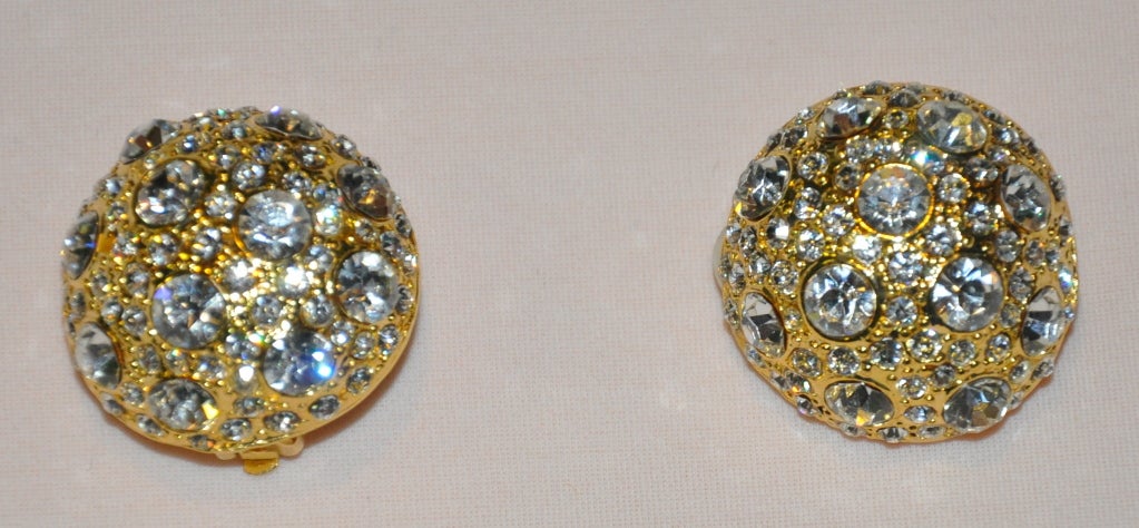 Gilded gold hardware clip-on earrings are accented with multi-sized Rhinestones. Earrings measures 1 1/4